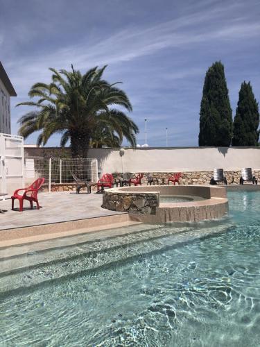 une piscine avec une fontaine en face d'un bâtiment dans l'établissement Campanile Perpignan Nord - Aéroport, à Rivesaltes