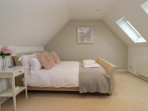1 dormitorio con cama blanca y ventana en The Firs Retreat, en Cheltenham