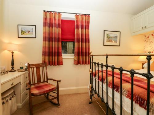 - une chambre avec un lit, une chaise et une fenêtre dans l'établissement The Homestead Lodge, à Windermere