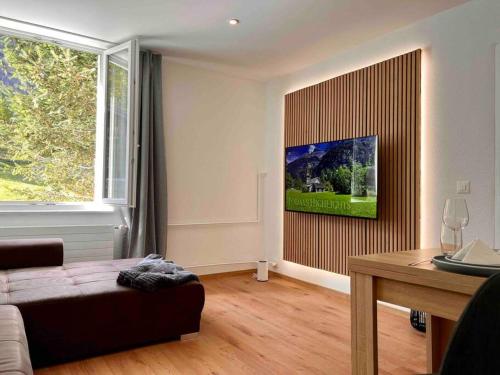 a living room with a couch and a large window at Wesley House in Kandersteg