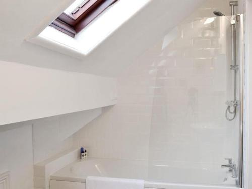 a white bathroom with a shower and a bath tub at The Rafters, Bank House, Stunning Apartment. in Millom