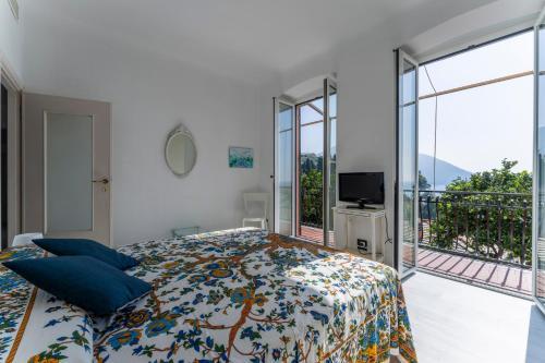 sypialnia z łóżkiem z niebieskimi poduszkami i balkonem w obiekcie A Due passi da Camogli 2 - Nice apartment with seaside view Recco Camogli w mieście Recco