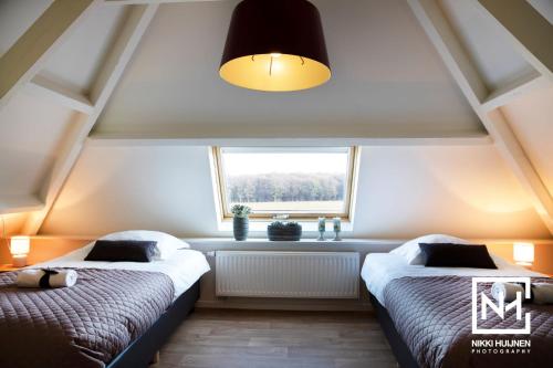 two beds in a room with a window at B&B Flamand in Heijenrath