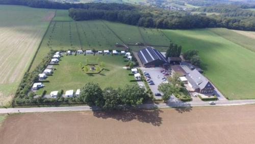 eine Luftansicht eines Betriebs mit einem großen Feld in der Unterkunft B&B Flamand in Heijenrath