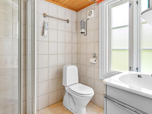 uma casa de banho com um WC, um lavatório e uma janela em Holiday home AVERØY VI em Stein