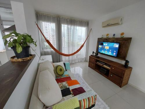 a living room with a couch and a flat screen tv at Não é studio, apto espaçoso 70m, 2 quartos, sacada fechada, garagem e bem no centro in Florianópolis