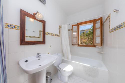 W łazience znajduje się umywalka, toaleta i lustro. w obiekcie Casa Juan w mieście Colonia de Sant Pere