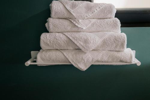 a stack of white towels on a shelf in a bathroom at Spacious studio near lake in Năvodari