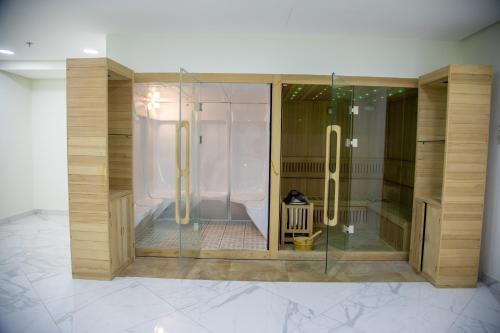 a bathroom with a shower with a glass enclosure at The Apple Residence in Juffair