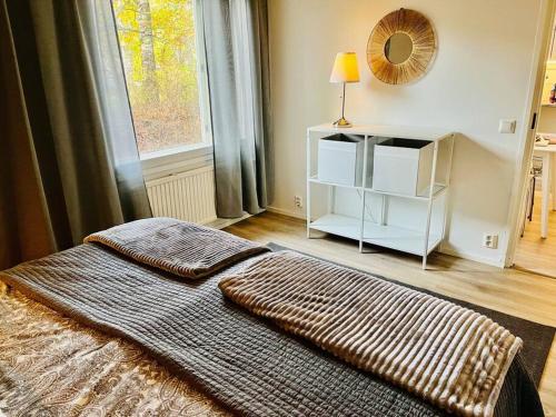 1 dormitorio con cama, ventana y espejo en Nice and cozy townhouse, en Rovaniemi