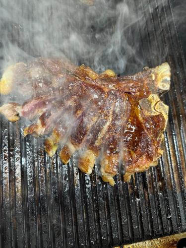 a piece of meat is cooking on a grill at Hotel Diana in Auronzo di Cadore