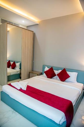 a bedroom with a large bed with red pillows at The Apple Residence in Juffair
