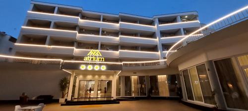 um grande edifício com luzes na lateral em Atrium Deluxe Resort em Golem