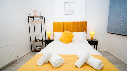 ein Schlafzimmer mit einem großen weißen Bett mit Handtüchern darauf in der Unterkunft Cozy 2 bed Apt with Private Garden in London
