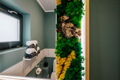 a wall of green and yellow flowers in a bathroom at Lake House in Năvodari