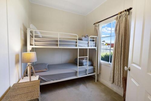 a bedroom with two bunk beds and a window at Katisha Cottage in Paynesville