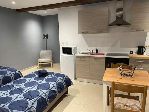 eine Küche und ein Schlafzimmer mit einem Bett und einem Tisch in der Unterkunft Studio proche de l’aéroport/gare/centre ville in Charleroi