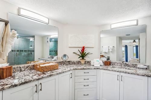 a bathroom with two sinks and a large mirror at Land's End 4-404 Bay Front - Premier in St. Pete Beach