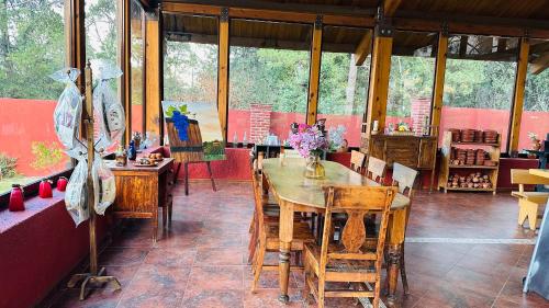 a dining room with a wooden table and chairs at Finca Los Angeles Hospederia & Sociales in Huasca de Ocampo
