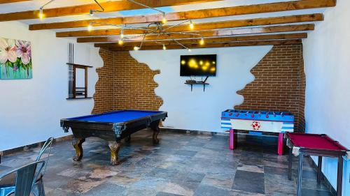 a room with a ping pong table and a brick wall at Finca Los Angeles Hospederia & Sociales in Huasca de Ocampo