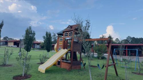a playground with a slide in a park at Finca Los Angeles Hospederia & Sociales in Huasca de Ocampo