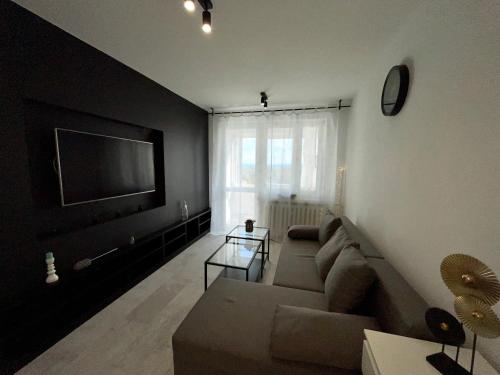 a living room with a couch and a flat screen tv at Panorama Apartment Kraków in Krakow