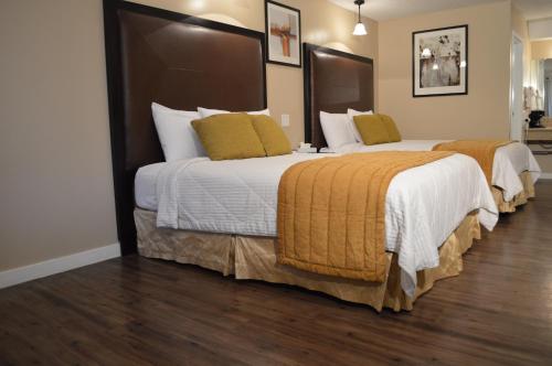 A bed or beds in a room at Laramie Valley Inn