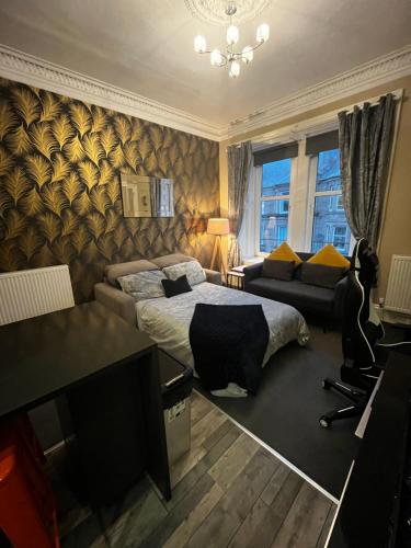 a bedroom with a bed and a desk and a couch at Stunning apartment on Perth Rd-mins from City Centre Dundee in Dundee