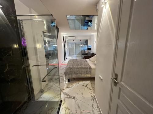 La salle de bains est pourvue d'une porte en verre menant à une chambre. dans l'établissement Fetish Studio, au Cap d'Agde