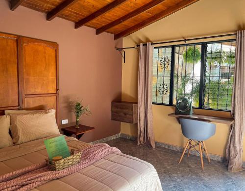 een slaapkamer met een bed, een bureau en een raam bij Cabin Retreat: Private Studio in Medellín