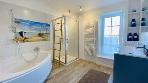 Un baño con bañera, ducha y lavabo. en Charme et authenticité pour cette villa rhétaise, en Sainte-Marie-de-Ré