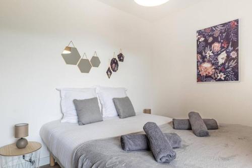 een slaapkamer met een groot bed met kussens erop bij La Belle Vue - Garage Terrasse Wi-Fi Netflix Disney+ in Annecy