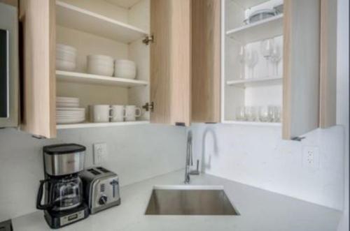 uma cozinha com um lavatório e uma bancada em Warm 3 BR Loft in Midtown em Nova York