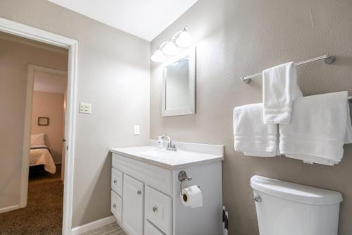 a bathroom with a sink and a toilet and towels at Allwood Cottage 1 in North Little Rock