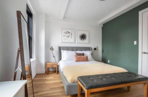 um quarto com uma cama e um banco em Warm 3 BR Loft in Midtown em Nova York