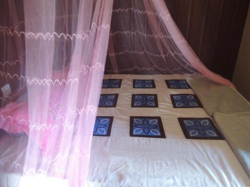 a bed with pink curtains and blue tiles on it at Bunyong Homestay in Siem Reap