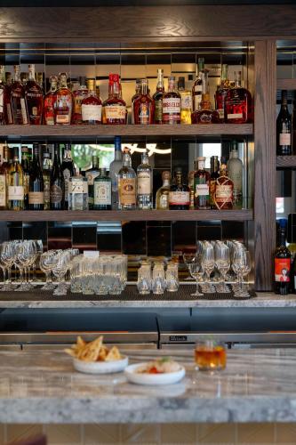 a bar with a lot of bottles and glasses of alcohol at The Myriad Hotel Louisville, Tapestry Collection by Hilton in Louisville