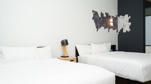 two beds in a room with white sheets at Aloft Ponce Hotel & Casino in Ponce