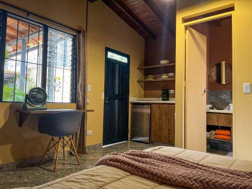 a bedroom with a bed and a desk and a kitchen at Cabin Retreat: Private Studio in Medellín
