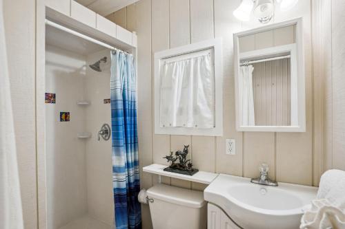 a bathroom with a sink and a toilet and a mirror at Beach House on the Sand in St Pete Beach