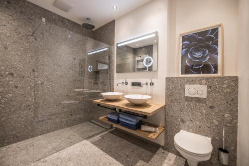 a bathroom with two sinks and a shower at Natur Zeit - Alpine Garden Apartments in Mayrhofen