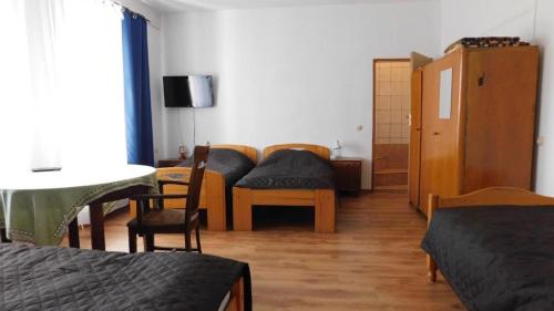 a room with two beds and a table and chairs at Gospodarstwo "Na Łęgach" in Lubcz Mały