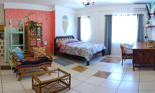 a bedroom with a bed and a chair and a table at Cool Vibes Beach Hostel in Dominical