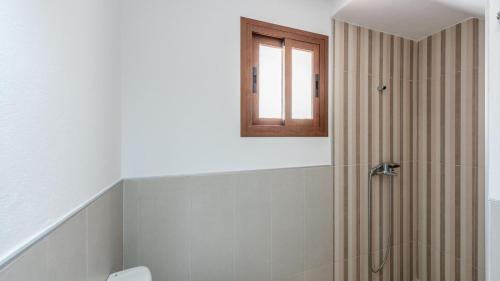 baño con ducha, aseo y ventana en Villa Los Abuelos Cartama by Ruralidays, en Cártama