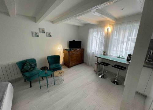 sala de estar con sofá, escritorio y sillas en Esprit Romantique, en Mulhouse