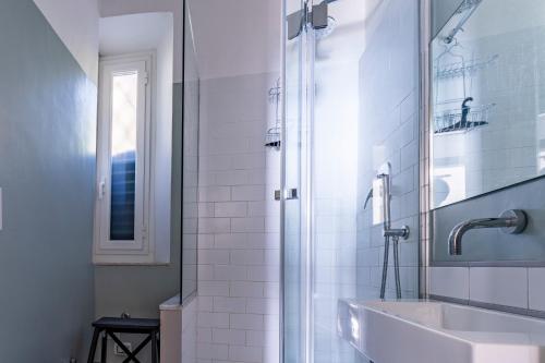uma casa de banho branca com um lavatório e um chuveiro em A due passi da Camogli Near to Camogli, apartment with terrace and seaside view em Recco