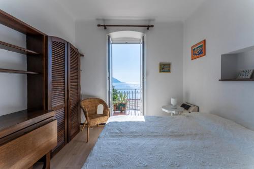una camera da letto con un letto e vista sull'oceano di A due passi da Camogli Near to Camogli, apartment with terrace and seaside view a Recco