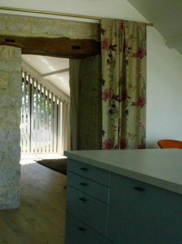 eine Küche mit einer Kommode in einem Zimmer mit einem Fenster in der Unterkunft Appartement lumineux in Dole