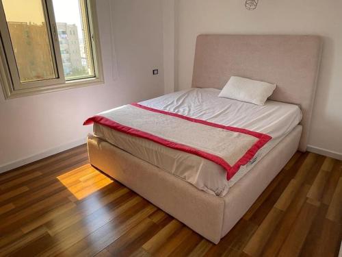 a large bed in a room with a wooden floor at luxury apartment at Obour, 5th floor no elevator in Cairo