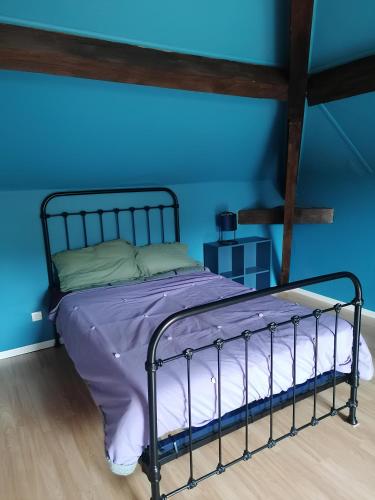にあるPour une halte aux portes de Bourgoinの青い壁のドミトリールームのベッド1台分です。